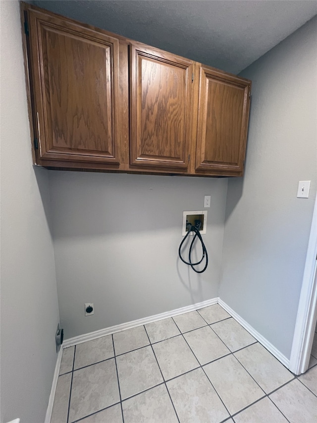 laundry room featuring light tile patterned flooring, cabinets, washer hookup, and electric dryer hookup