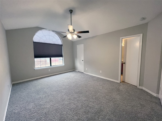 empty room with vaulted ceiling, carpet floors, and ceiling fan