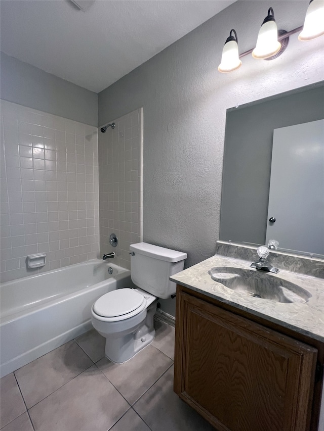 full bathroom featuring tile patterned flooring, vanity, tiled shower / bath combo, and toilet