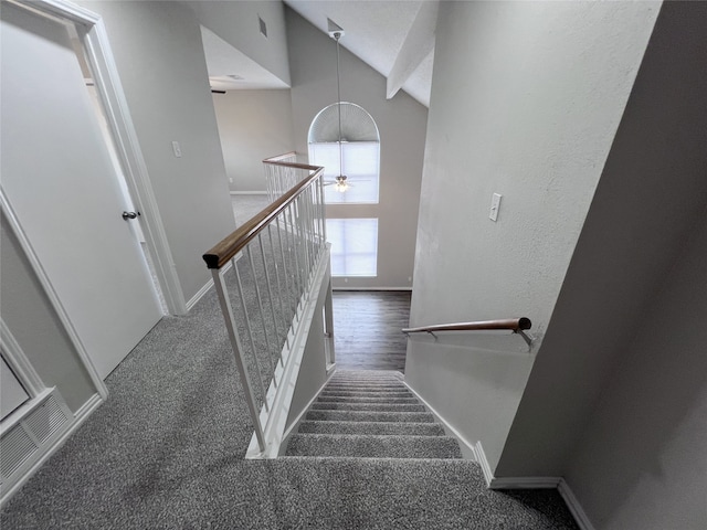 staircase featuring high vaulted ceiling