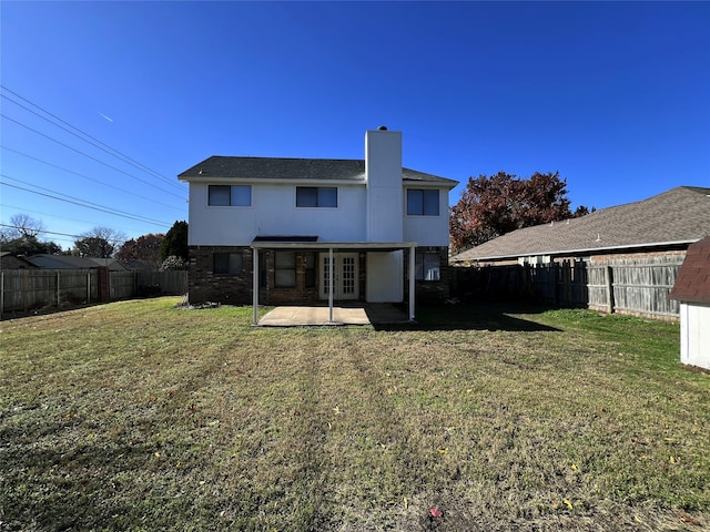 back of house with a patio area and a lawn