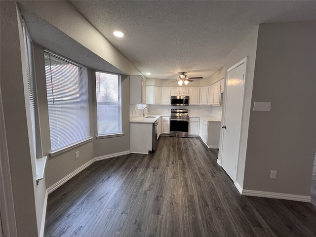 kitchen featuring sink, stainless steel appliances, a textured ceiling, white cabinets, and dark hardwood / wood-style flooring