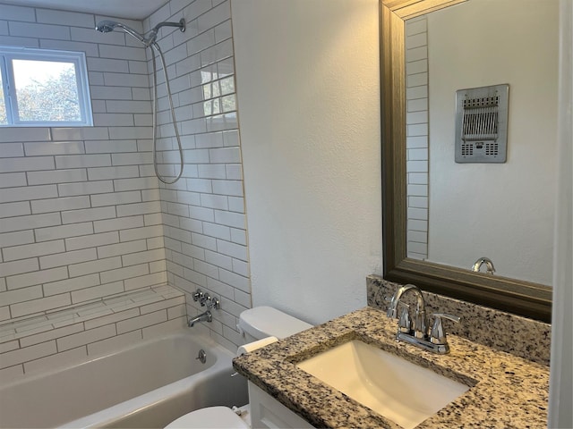 full bathroom featuring vanity, tiled shower / bath combo, and toilet