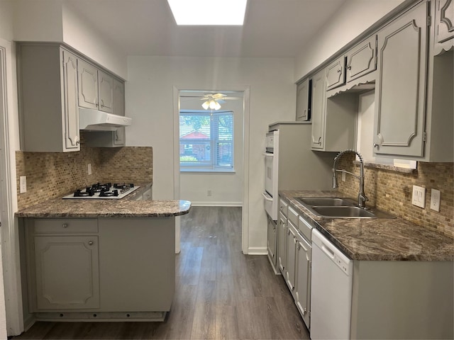 kitchen with gray cabinetry, white appliances, ceiling fan, dark wood-type flooring, and sink