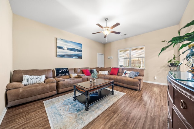 living room featuring dark wood-type flooring and ceiling fan