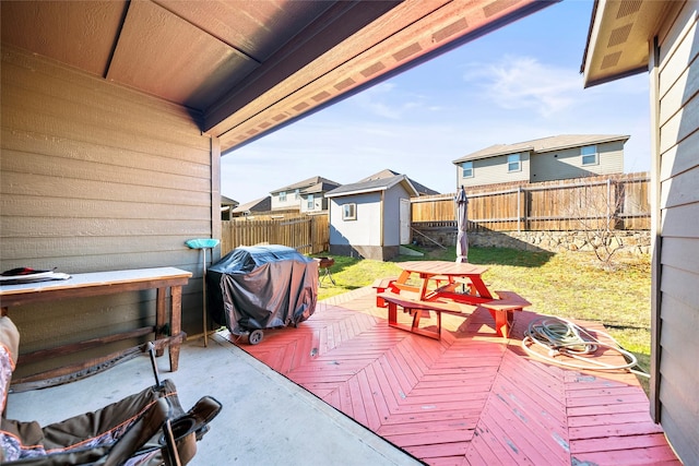 wooden terrace with area for grilling and a shed