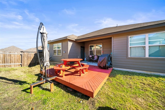 rear view of property featuring a yard and a deck