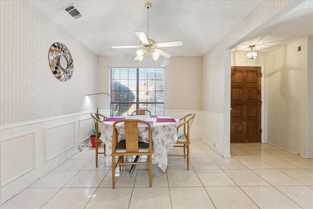 dining area featuring ceiling fan, light tile patterned floors, and a textured ceiling