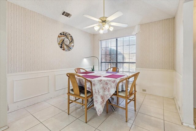 tiled dining room featuring ceiling fan and a textured ceiling