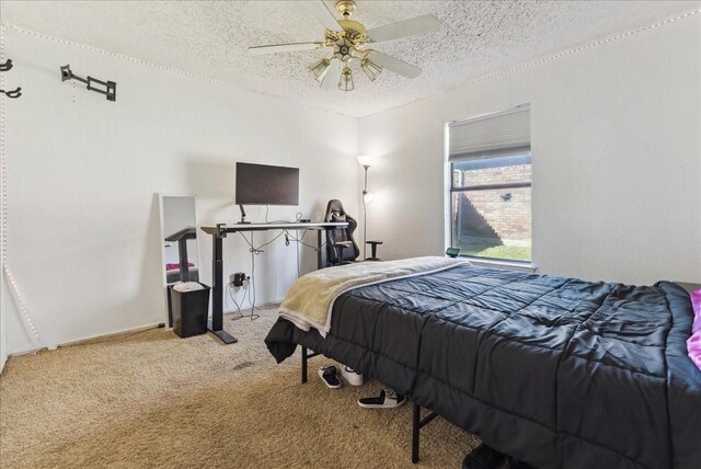 carpeted bedroom featuring a textured ceiling and ceiling fan