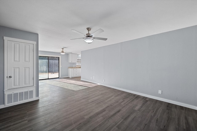 unfurnished living room featuring ceiling fan and dark hardwood / wood-style flooring