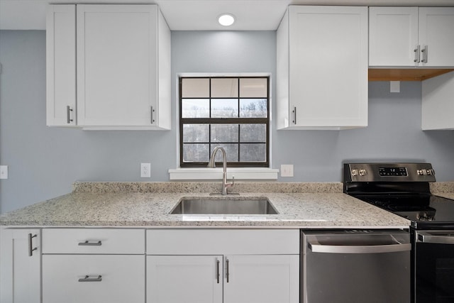 kitchen with appliances with stainless steel finishes, white cabinetry, and sink