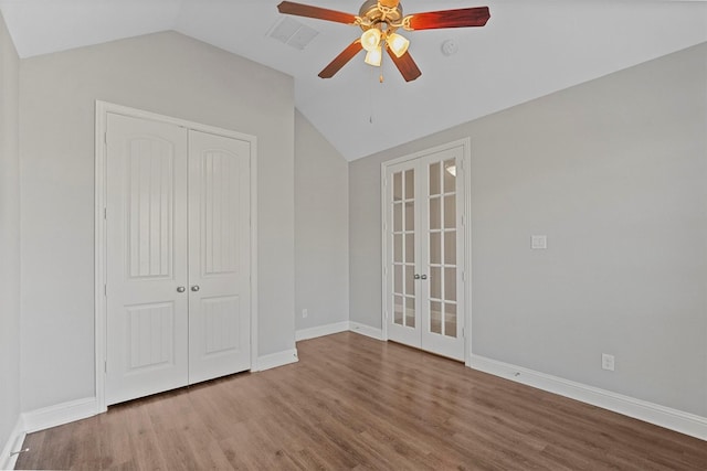 unfurnished bedroom with lofted ceiling, french doors, ceiling fan, wood-type flooring, and a closet