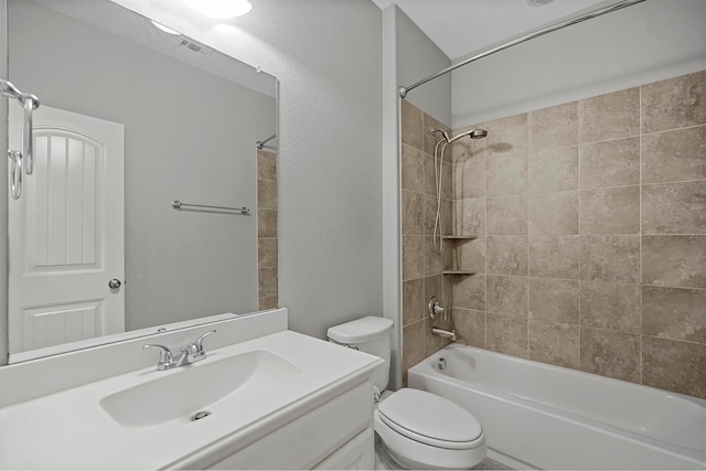 full bathroom with tiled shower / bath combo, toilet, and vanity