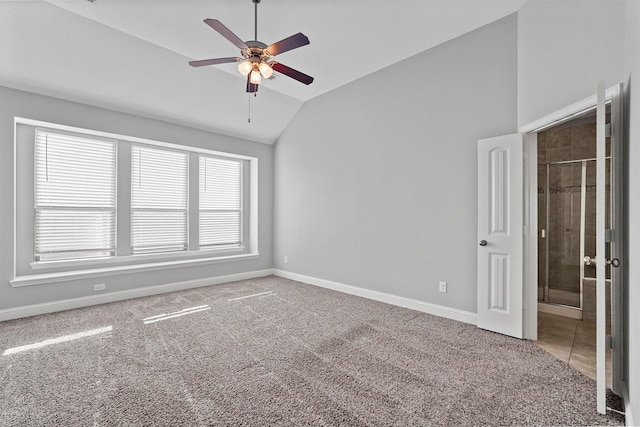 carpeted spare room featuring ceiling fan and vaulted ceiling