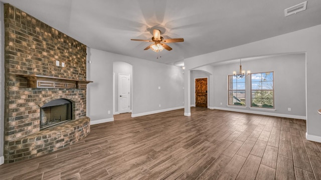 unfurnished living room featuring a fireplace, hardwood / wood-style floors, and ceiling fan with notable chandelier