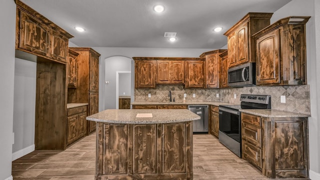 kitchen featuring tasteful backsplash, sink, a center island, and appliances with stainless steel finishes