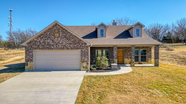 view of front of house with a front lawn, covered porch, and a garage