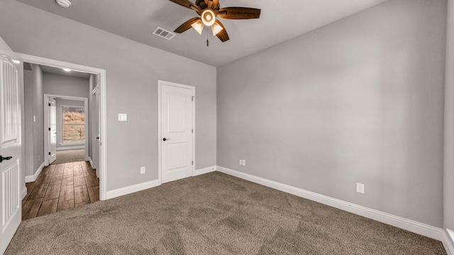 unfurnished bedroom featuring ceiling fan and dark carpet