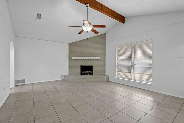 unfurnished living room featuring a textured ceiling, ceiling fan, light tile patterned floors, lofted ceiling with beams, and a fireplace