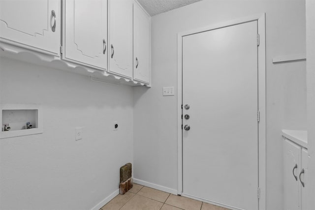 washroom featuring washer hookup, cabinets, hookup for an electric dryer, a textured ceiling, and light tile patterned floors