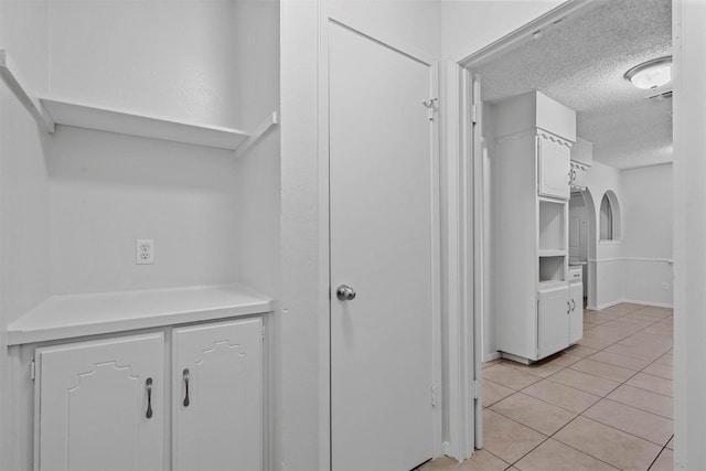 spacious closet with light tile patterned floors