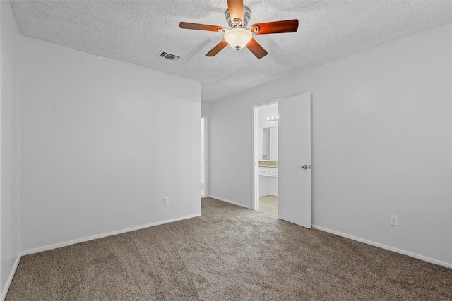 carpeted empty room featuring ceiling fan and a textured ceiling