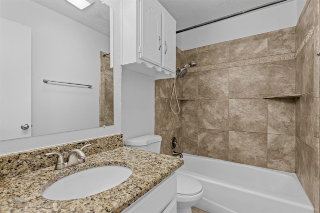 full bathroom with tiled shower / bath combo, toilet, a textured ceiling, and vanity