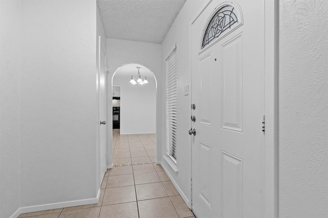 hall with light tile patterned flooring and a textured ceiling