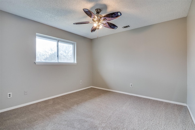 empty room with ceiling fan, carpet floors, and a textured ceiling