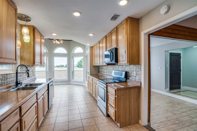 kitchen featuring decorative backsplash, pendant lighting, stainless steel appliances, and sink