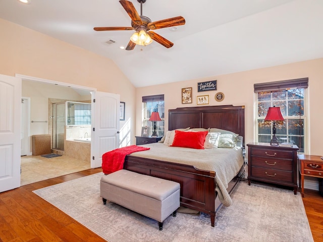 bedroom with light hardwood / wood-style floors, ceiling fan, lofted ceiling, and ensuite bathroom