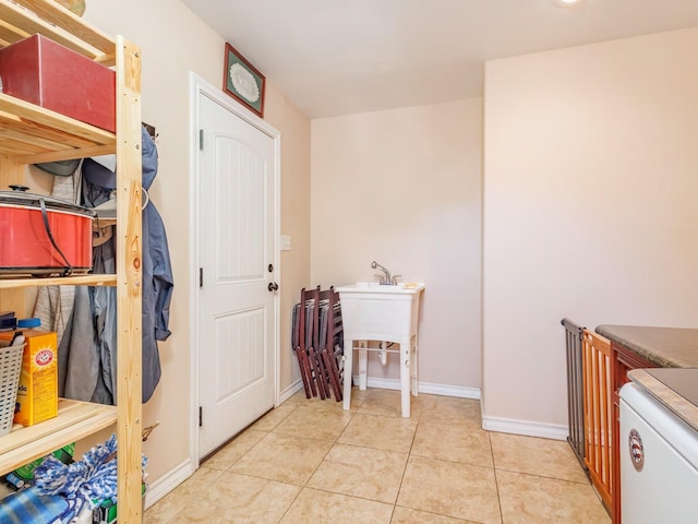 clothes washing area featuring light tile patterned floors