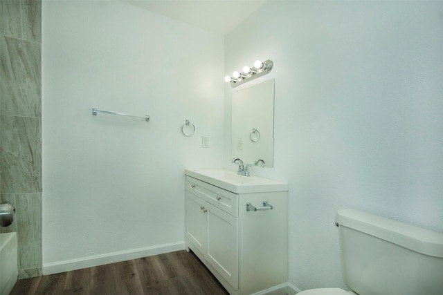 bathroom with hardwood / wood-style flooring, vanity, and toilet