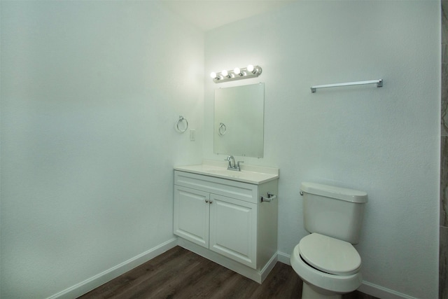 bathroom with hardwood / wood-style floors, vanity, and toilet