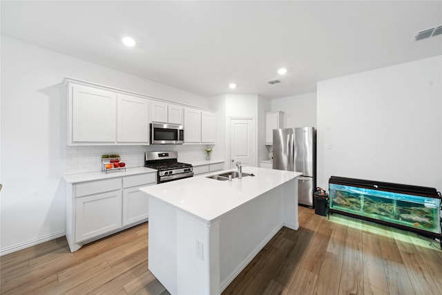 kitchen featuring sink, a center island with sink, white cabinets, and appliances with stainless steel finishes