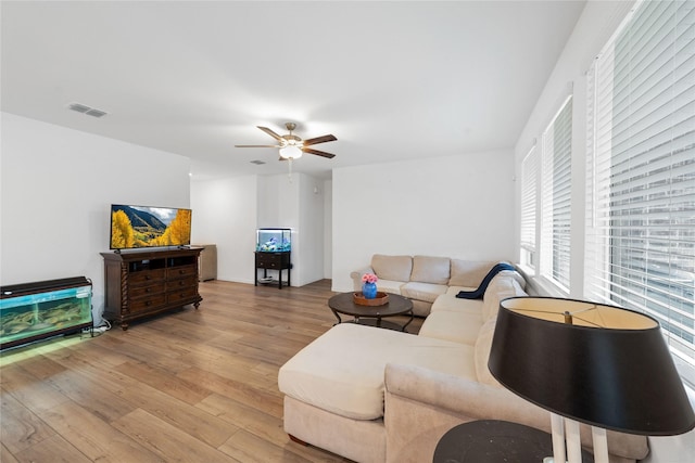 living room with ceiling fan and light hardwood / wood-style flooring