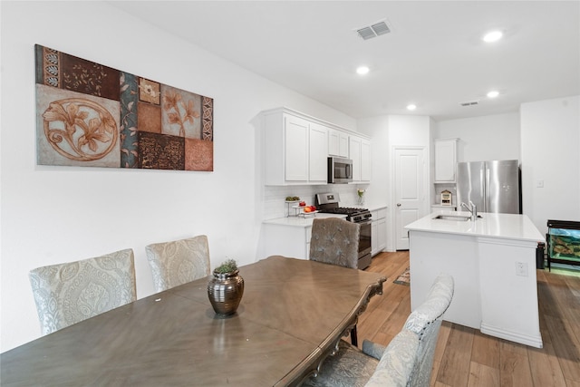 dining space featuring hardwood / wood-style floors and sink