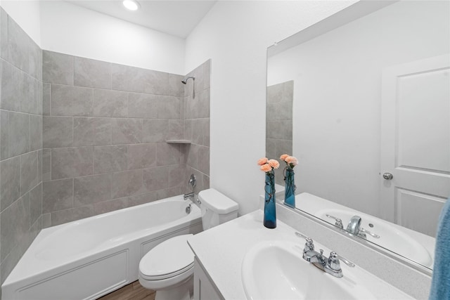 full bathroom with toilet, vanity, and tiled shower / bath