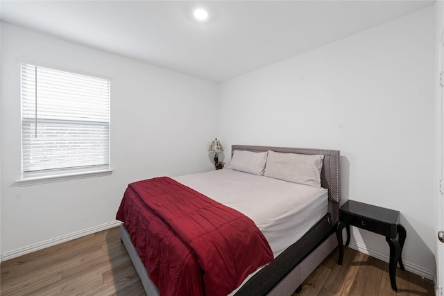 bedroom with dark hardwood / wood-style flooring and multiple windows