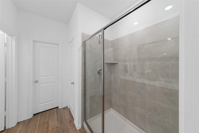 bathroom with hardwood / wood-style floors and a shower with door