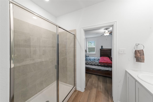 bathroom featuring vanity, hardwood / wood-style flooring, a shower with door, and ceiling fan