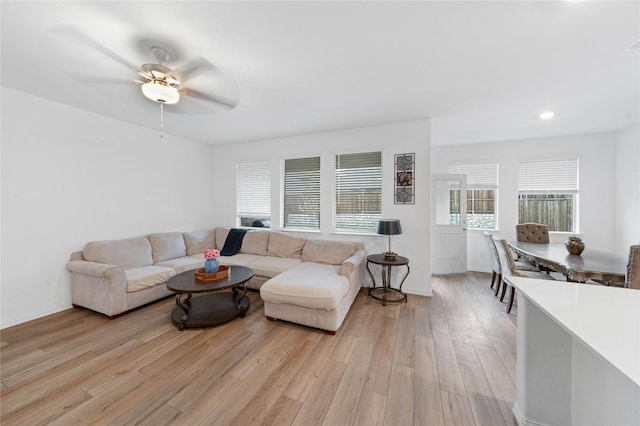 living room featuring ceiling fan and light hardwood / wood-style floors