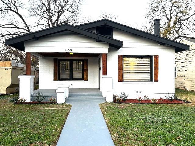 bungalow with a front yard and a porch