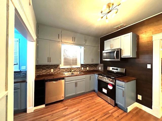 kitchen featuring gray cabinetry, light hardwood / wood-style floors, sink, and appliances with stainless steel finishes