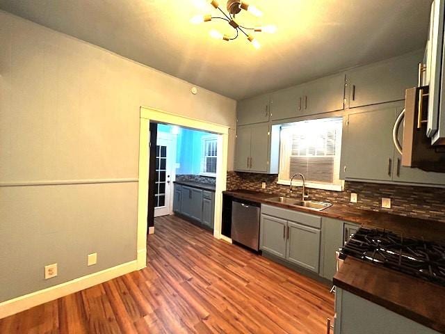 kitchen featuring sink, an inviting chandelier, tasteful backsplash, gray cabinets, and appliances with stainless steel finishes