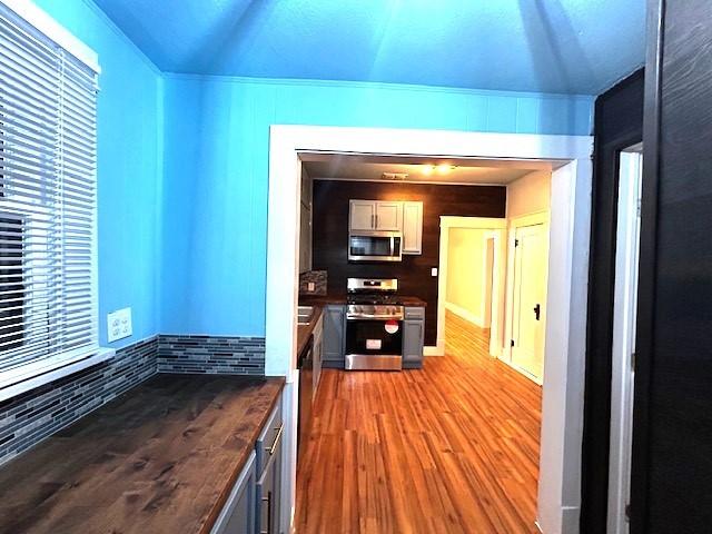 kitchen featuring gray cabinetry, light wood-type flooring, and appliances with stainless steel finishes