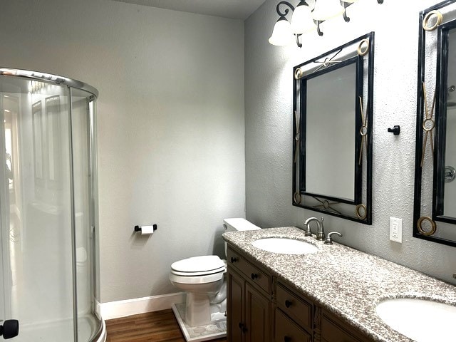 bathroom featuring hardwood / wood-style floors, vanity, toilet, and walk in shower