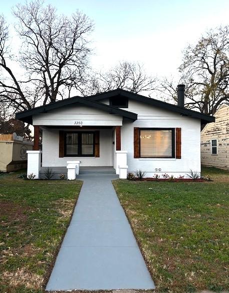 view of front facade featuring covered porch and a front lawn