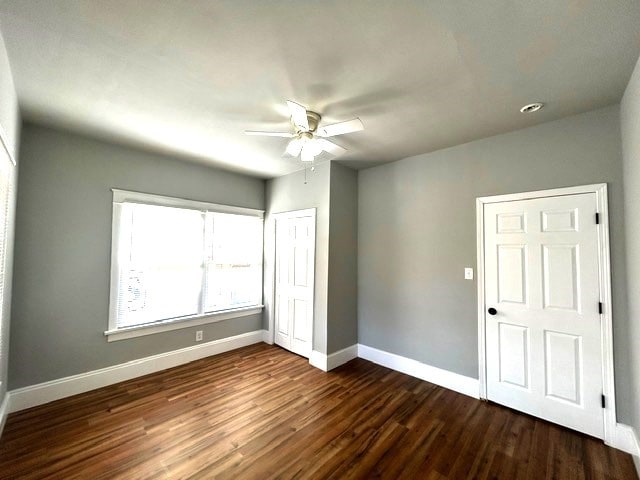 unfurnished bedroom with ceiling fan and dark hardwood / wood-style flooring